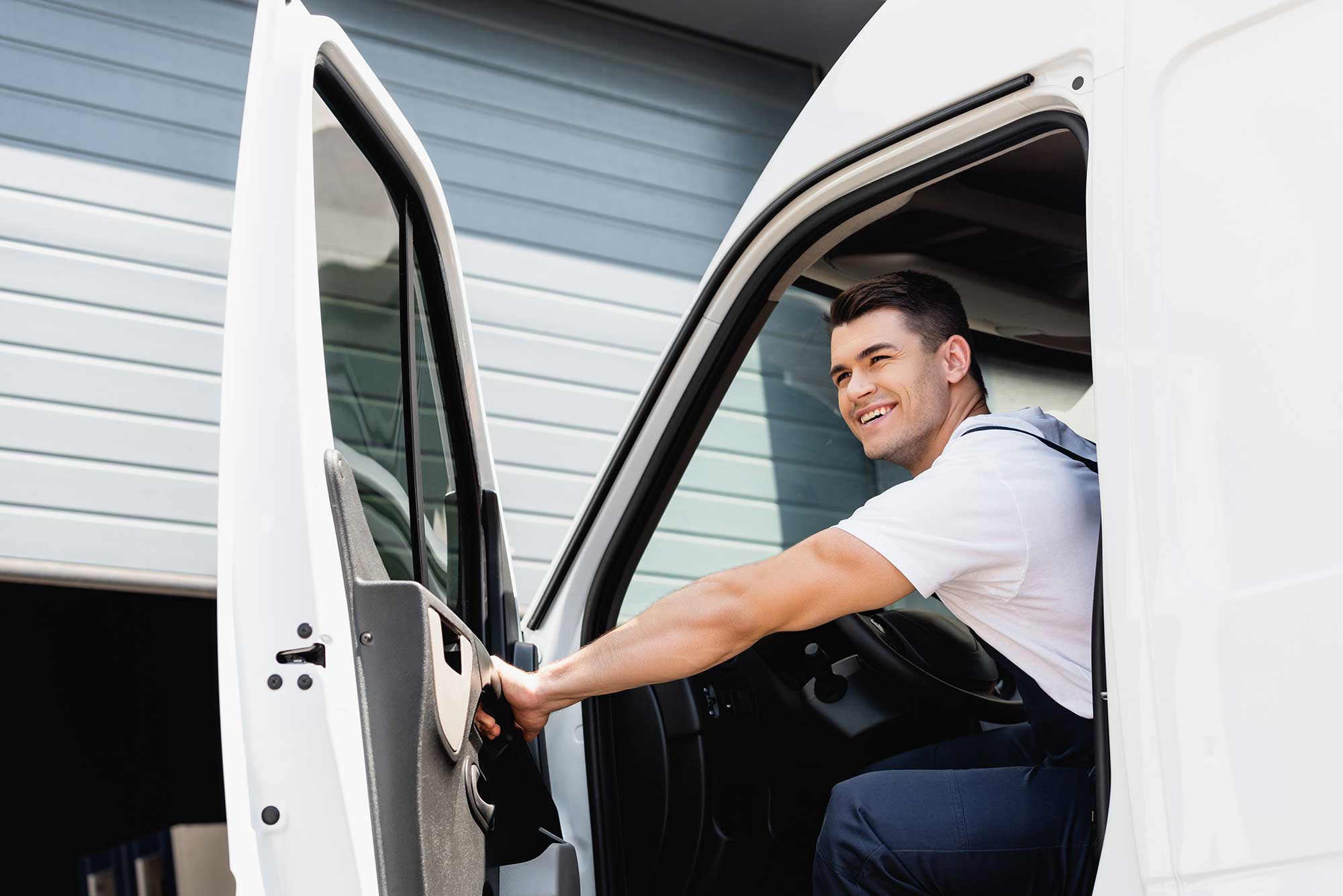 A local HVAC company technician smiling while arriving at a customer's home for a heating and cooling service call.