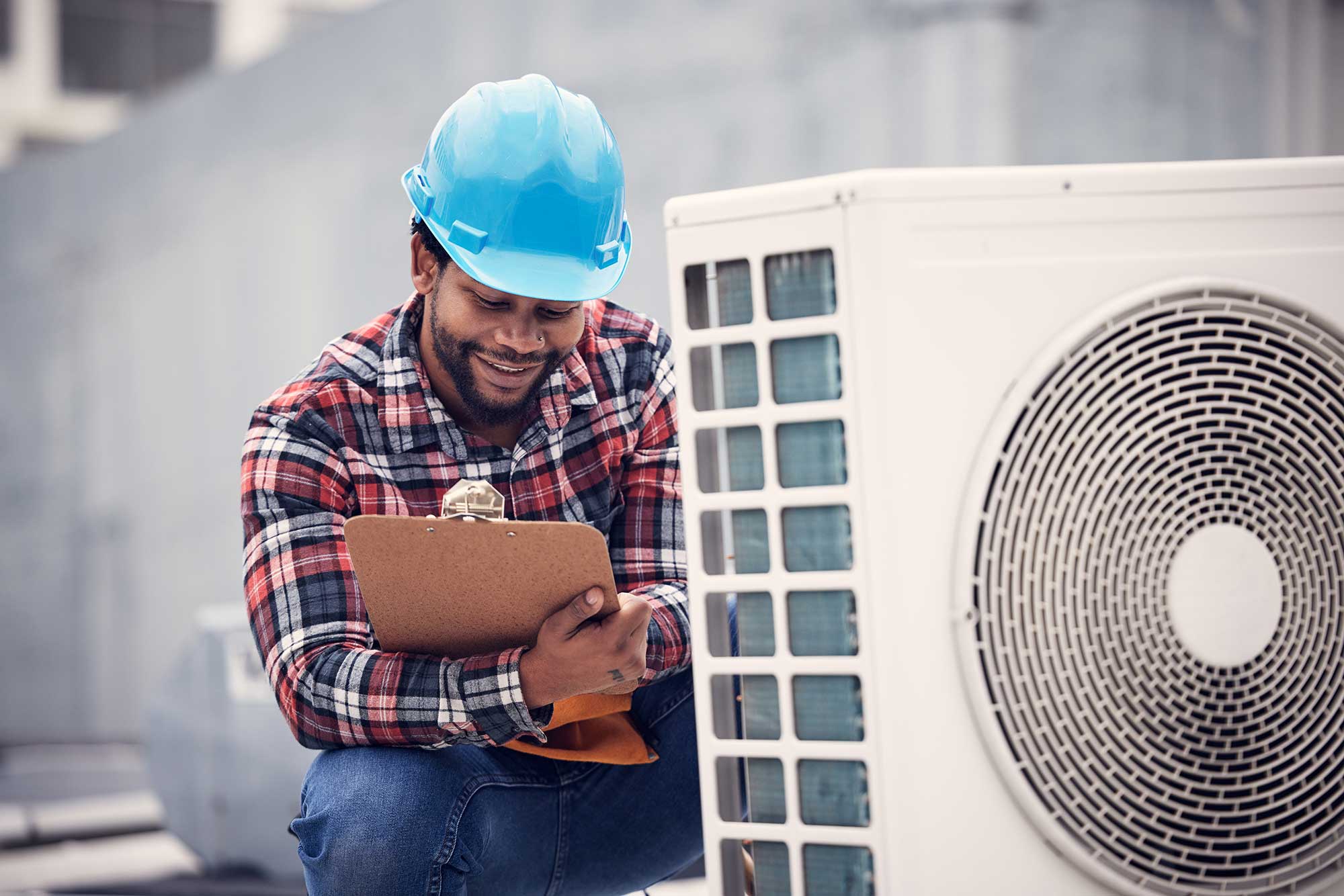 An air conditioning repair service technician performing annual inspection outdoors.